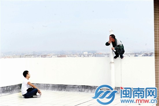 男子蹲在圍墻上