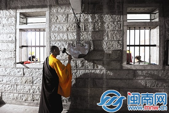 寺院僧人敲響鐘板