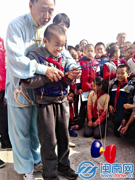 老人教小朋友抖空竹