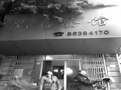 洪鳳媚站在自家店門口，看著“凰嘉餐館”4個字黯然