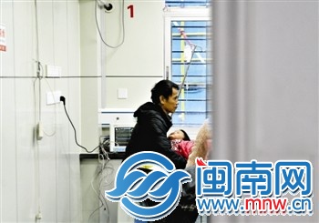 病房內(nèi)，一位親戚抱著3歲的小麗，呆望著