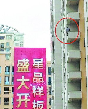 該男子爬上高樓，半身懸空，十分危險