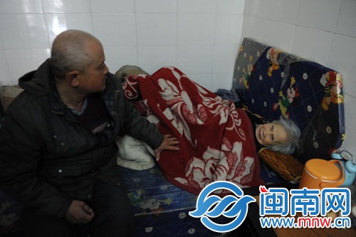 譚長福的家有點背陰，床沒有床墊，被子沒有被套