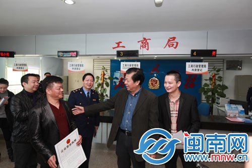 陳榮洲（右二）給企業(yè)法定代表人頒發(fā)新版營業(yè)執(zhí)照
