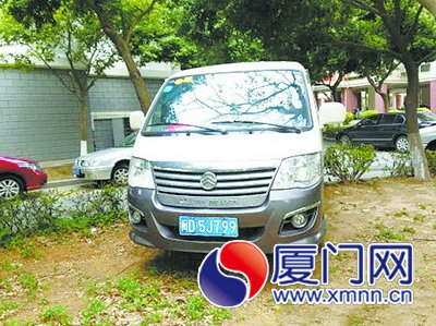 這部公務(wù)車輛停在小區(qū)綠化帶上