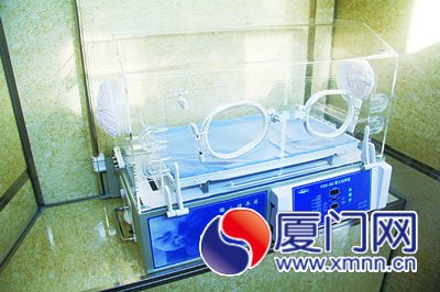 右邊放置著一臺(tái)嬰兒保溫箱，左邊有張床