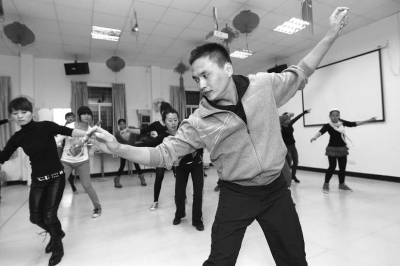 鄧少坤正在教20多名婦女跳廣場(chǎng)舞