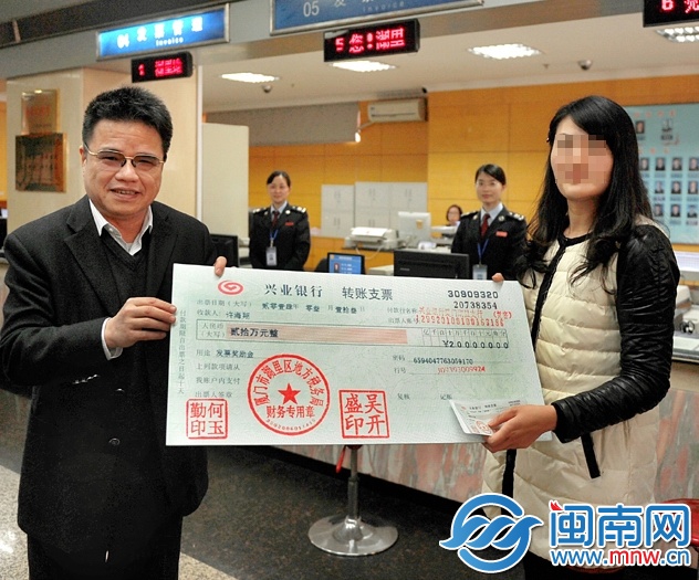 許女士從廈門市地稅局局長吳振坤手中接過20萬元的“