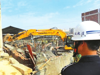 大型鉤機對違法建筑進行強制拆除