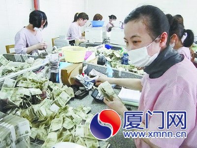 點(diǎn)鈔工邱麗珊（右）干起活來(lái)一絲不茍。