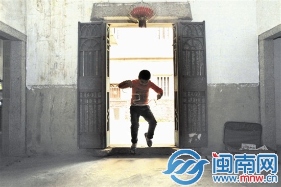 小斌一個人在房門口玩著膠帶，仿如孤獨的舞者