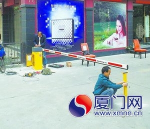 工人在酒店門前安裝停車場道閘。