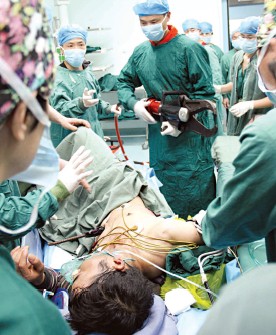 手術(shù)室里消防員手持液壓剪為受傷男子剪斷鋼筋