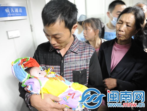 寶寶在叔叔的懷中，睜著大眼好奇地張望著