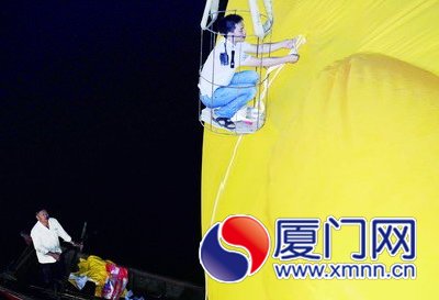 工人給大黃鴨系上繩子，準(zhǔn)備起吊