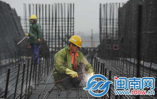 泉州跨海大橋橋面上的工人雨中電焊鋼筋