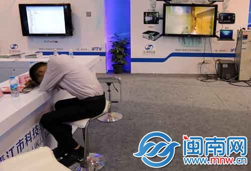 一位工作人員趴在前臺上休息