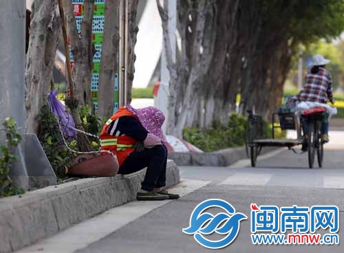 一位環(huán)衛(wèi)工人坐在路邊休息