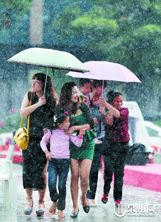 在泉州市區(qū)寶洲街，市民雨中出行