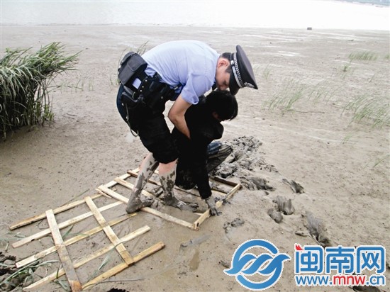 民警將木板鋪在泥潭上，慢慢靠近蘇某后將他拉出