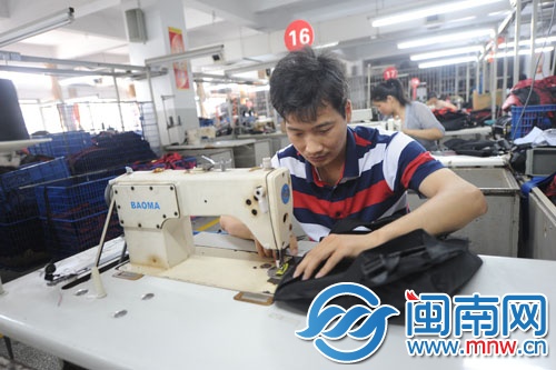 一名職工正認(rèn)真地縫包