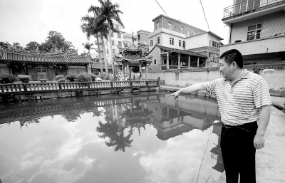 姚河水在孩子落水的池塘邊向記者回憶事情經(jīng)過(guò)。