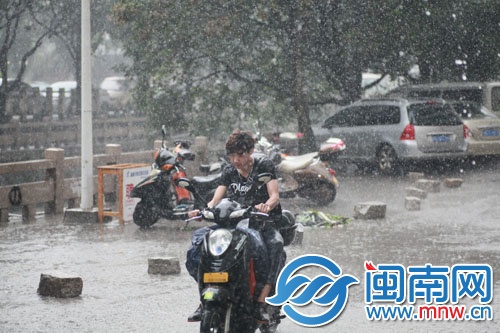 和昌花苑外騎電動(dòng)車的小伙被淋得眼睛都睜不開(kāi)