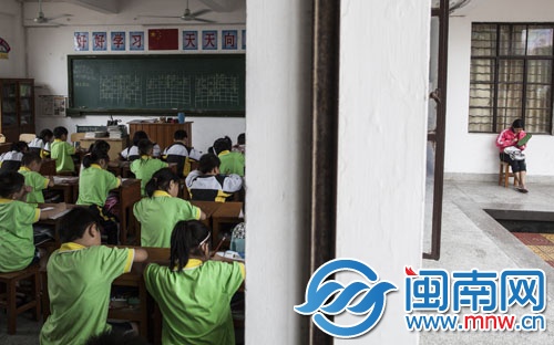 兒子在教室內(nèi)上課，母親怕自己睡著，在教室外鉤著毛