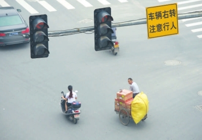 闖紅燈、不戴頭盔現(xiàn)象時(shí)有發(fā)生。本報(bào)記者陳明哲攝