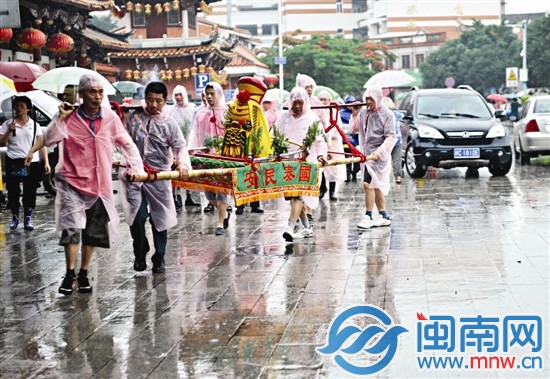 抬著神像，冒雨踩街祈福