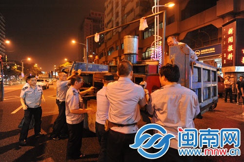 執(zhí)法人員在泉秀街沉洲路口沒收占道的燒烤攤