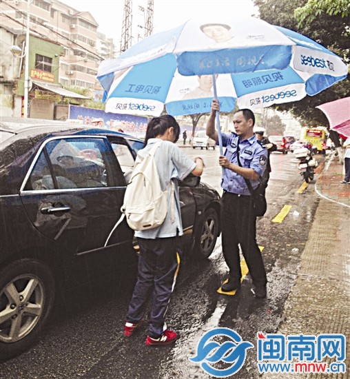 廈門一中考場外，一名民警幫考生撐傘