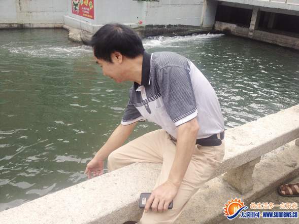 林添水當時就是這樣夾住石質護欄，合力將男孩拉起。