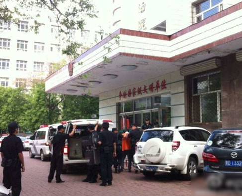 兩名犯罪嫌疑人頭戴面罩，被法警押進法庭。2