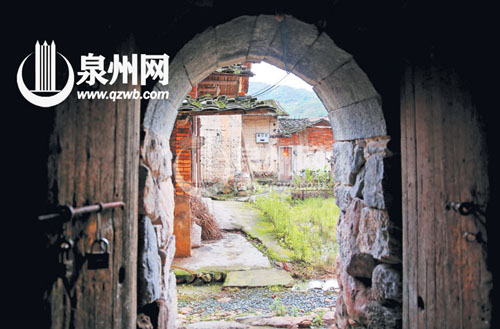 這一石拱門是土樓的邊門，對面是土樓的配套古厝。