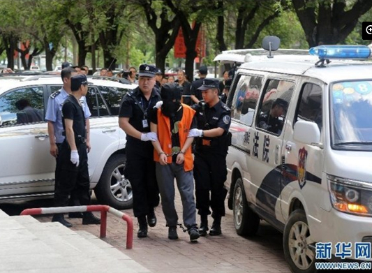 兩名犯罪嫌疑人頭戴面罩，被法警押進法庭。