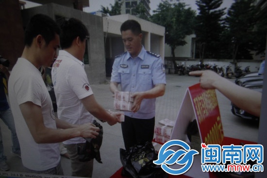受害人陳先生從民警手中領(lǐng)回被騙的40萬元