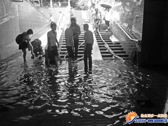 行人脫掉鞋襪蹚水而過 記者 劉宇瀚 攝