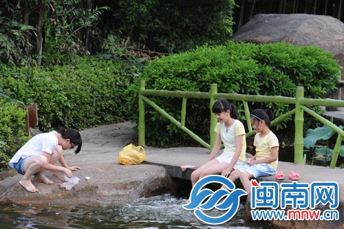 天氣太熱，坐在水邊玩水，讓腳涼快些