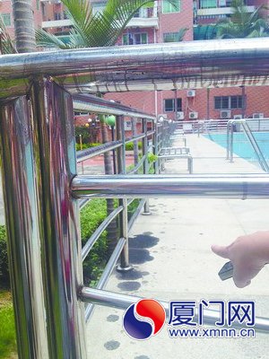 游泳池的欄桿和地上都是油污。