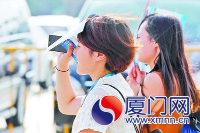 昨日下午艷陽高照，行人用廣告紙遮陽