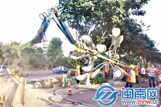 大坑邊的一座路燈暫時(shí)被拆卸，壓樁機(jī)正在打樁