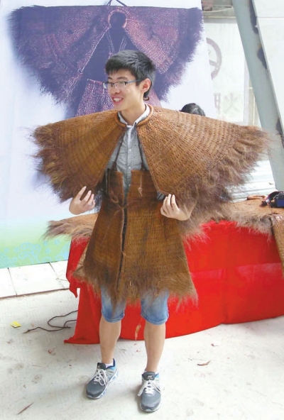 來賓興致勃勃地試穿陳奕培制作的蓑衣。