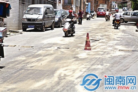 津?qū)毬飞系挠臀?，兩個好心人已經(jīng)用沙子鋪在路上