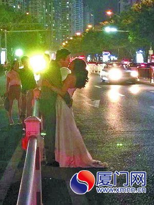 新人在車流滾滾的馬路中擁吻