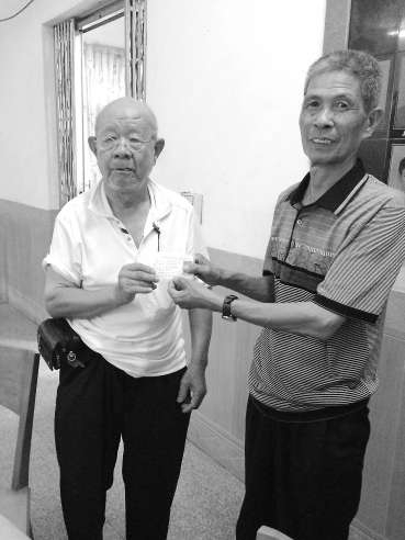 吳基揚(yáng)（左）將辦好的證件遞交給村民。