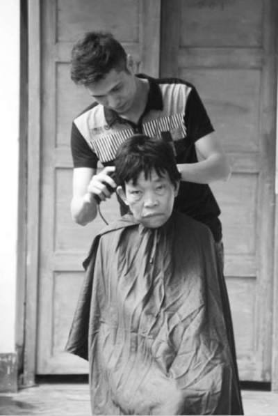 梁江華正在給老人理發(fā)。